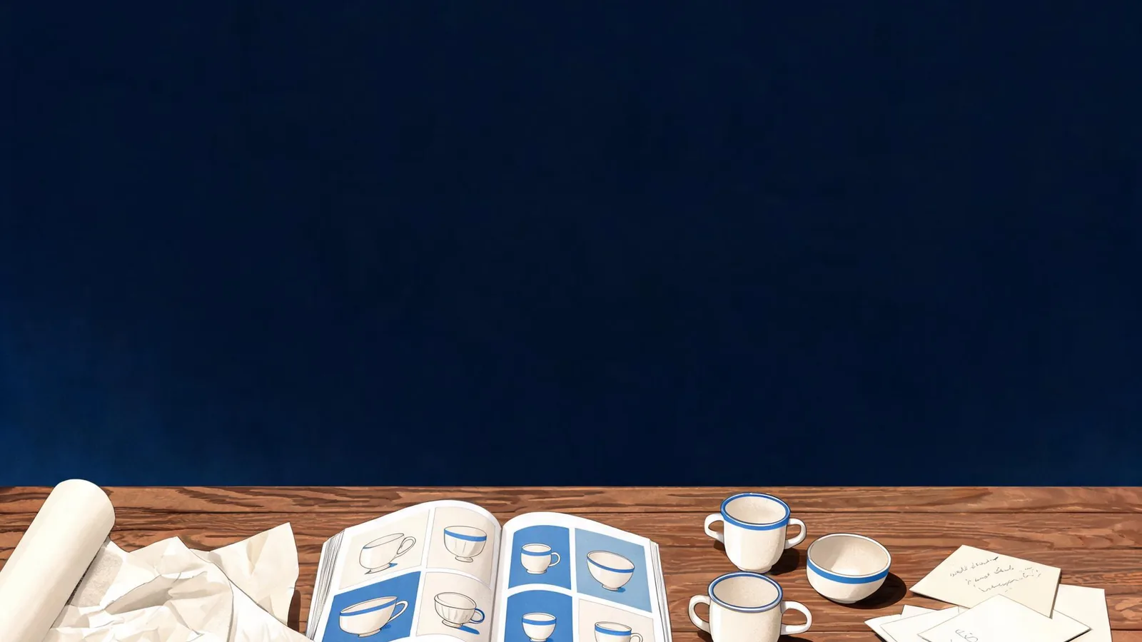 Cited — a small merchant workstation with an open product catalogue, ceramic goods, packing paper, and handwritten buyer questions on a wood counter